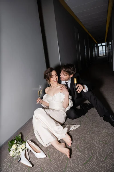 Sposo Felice Vestito Nero Bottiglia Tenuta Seduto Vicino Splendida Sposa — Foto Stock