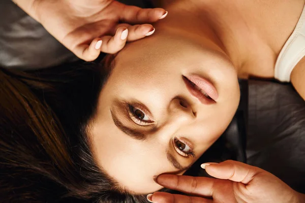 Yüzüne Dokunup Kameraya Bakarken Yatakta Uzanan Doğal Makyajlı Kilolu Kadın — Stok fotoğraf