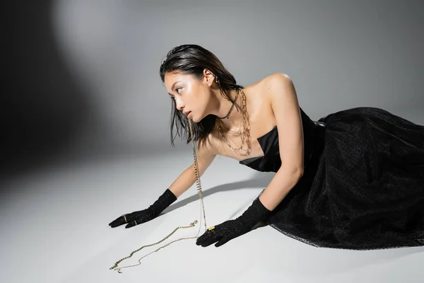 Azjatycki Model Krótkimi Brunetkami Włosy Trzymając Złotą Biżuterię Ustach Podczas — Zdjęcie stockowe