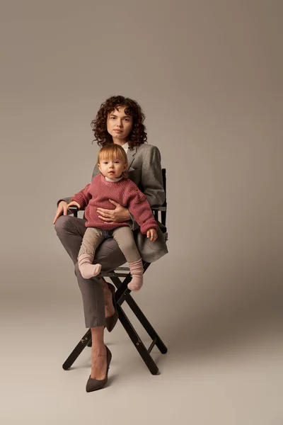 バランスのとれたライフスタイル 成長と家族 灰色の背景の娘と椅子に座っている中仕事の母親 プロの成功 マルチタスク 品質時間 ワークライフバランスの概念 — ストック写真