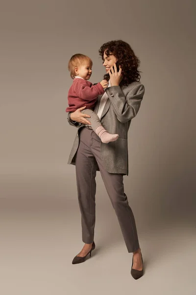 현대의 성공적 경력쌓기 능력있는 어머니 스마트폰으로 이야기하는 배경에팔에 아기를 어머니로서의 — 스톡 사진