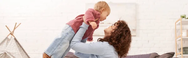 Quality Family Time Curly Woman Lifting Toddler Daughter Cozy Living — Stock Photo, Image