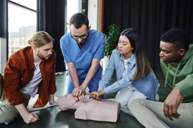 İlk yardım eğitimi, kalp masajı üzerine kardiyopulmoner resüsitasyon gösteren tıbbi eğitmen eğitim odasında çok ırklı katılımcılar, etkili hayat kurtarma becerileri ve teknikler konsepti.