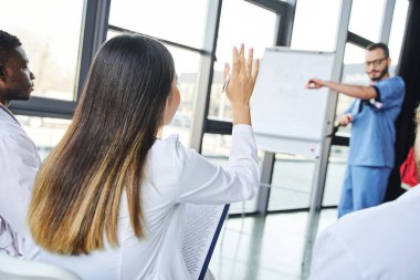 İlk yardım semineri, bulanık tıp eğitmeninin baskıcı turnike göstermesi, genç bir kadının çok ırklı grupların yanında araştırma yapması, acil durum hazırlığı ve hayat kurtarma becerileri konsepti.