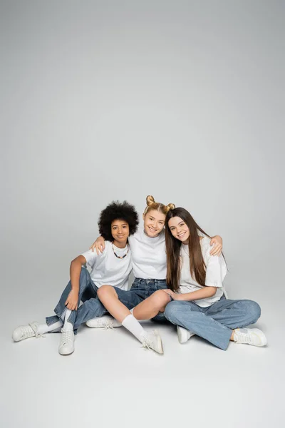 Fuld Længde Smilende Interracial Teenager Veninder Hvide Shirts Blå Jeans - Stock-foto