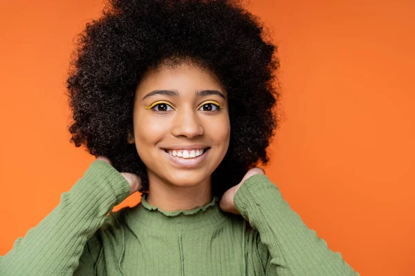一个面带微笑的年轻非洲裔美国女孩的画像 她身穿绿色连衣裙 动人的头发 凝视着被橙色 青少年服装和一代Z概念隔离的相机 — 图库照片