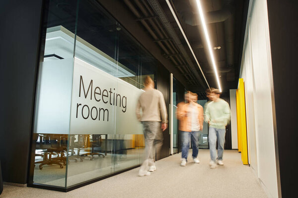 motion blur of energetic and ambitious business people walking near meeting room in coworking environment of modern office with high tech interior, full length, dynamic business concept