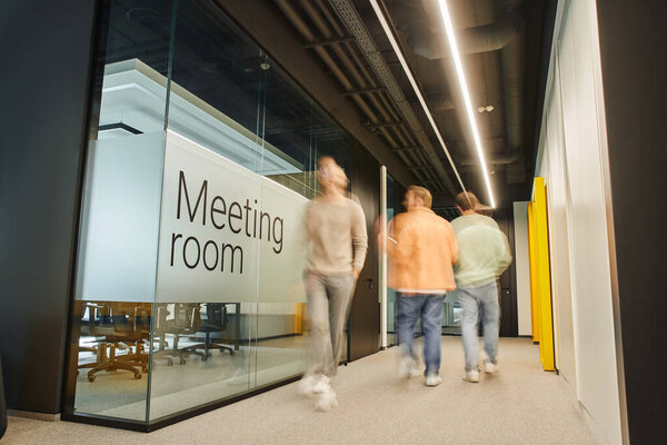long exposure of successful entrepreneurs walking along meeting room in corridor of modern coworking office with high tech interior, dynamic business concept