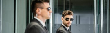 bodyguard service, hotel security, handsome man in suit and sunglasses standing in lobby near work partner, vigilance, protection and job, professional headshots, looking at camera, banner clipart