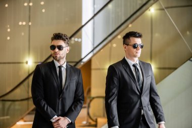 security measures of luxury hotel, two handsome men in formal wear and sunglasses, bodyguards on duty, safety management, vigilance, suits and ties, private security, strong guards  clipart