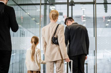 security service, personal protection, back view of blonde woman and her daughter leaving hotel next to bodyguards, private safety, rich lifestyle, guards on duty  clipart