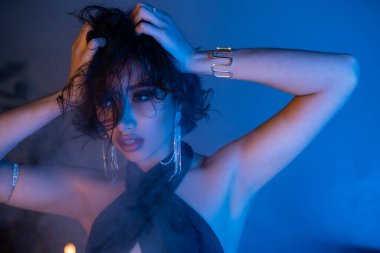 Saç stili olan şık Asyalı bir kadın. Gece kulübünde duman ve neon ışıkta dans ediyor.