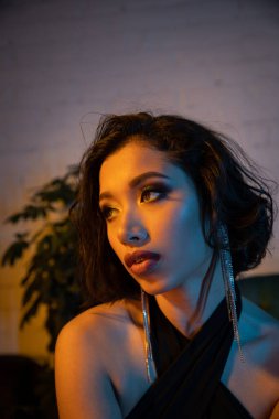Kendine güveni olan genç Asyalı kadın gece kulübünde akşam yemeği yiyor.