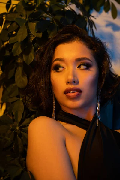 Pewna Siebie Młoda Azjatycka Kobieta Makijażem Patrząc Pobliżu Roślin Klubie — Zdjęcie stockowe