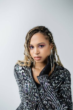 Aksesuarlar, mücevherler ve eldivenler, gri arka planda poz veren Afrikalı Amerikalı kadın, cesur bir tarz.