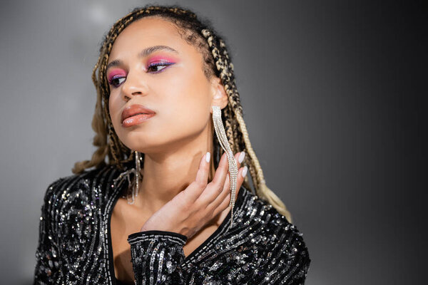 красивая африканская американка с смелым макияжем на сером фоне, вечеринки, глядя в сторону