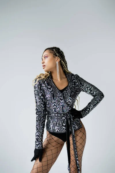 stock image bold style, african american woman posing with hand on hip, grey background, self-expression