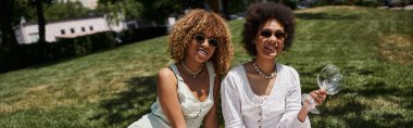 Yaz pikniği, mutlu Afro-Amerikalı kadın şarap kadehleriyle şık kız arkadaşının yanında, afiş