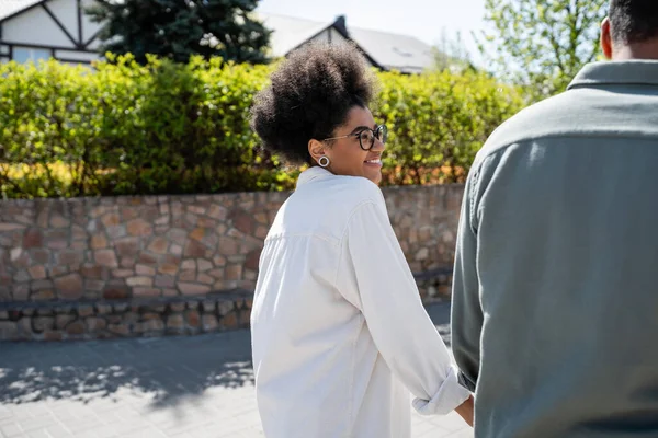 笑顔のアフリカ系アメリカ人女性 シャツと眼鏡で 都会のストリートでボーイフレンドを見ている — ストック写真