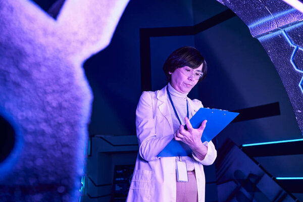 футуристическое исследование, женщина-ученый пишет в буфер обмена рядом с экспериментальным оборудованием