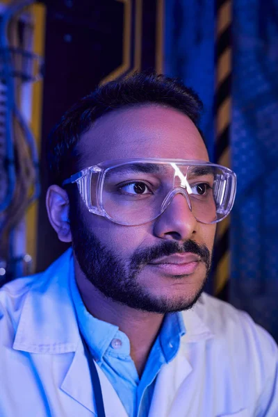 portrait of bearded indian scientist in goggles in innovation hub, exploring future