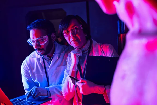 Hintli meslektaşı olan kadın bilim adamı gelecekteki bilim merkezinde dizüstü bilgisayar kullanıyor.