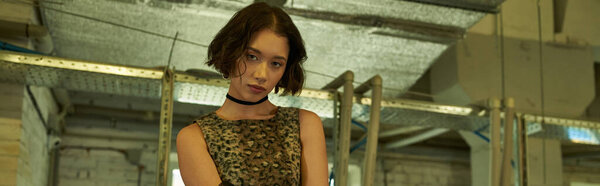 модная молодая азиатская женщина смотрит в камеру в публичной прачечной, баннер