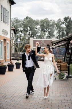 Coşkulu, çoklu etnik çeşitlilikte yeni evliler dans ediyor ve şehir sokaklarında el ele tutuşuyorlar, açık havada kutlama yapıyorlar.