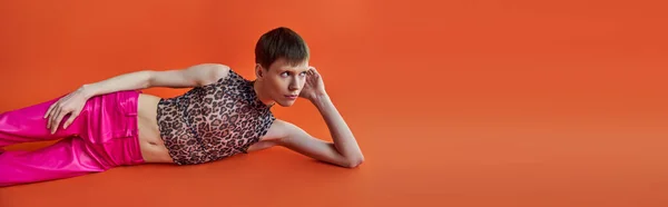 Queer Person Leopard Print Top Pink Pants Lying Orange Backdrop — Stock Photo, Image