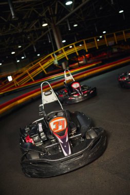 modern racing cars inside of indoor circuit, motor race vehicles, go kart for speed racing clipart