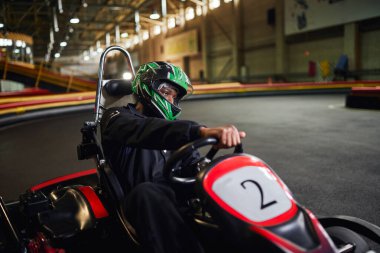 Go kart sürüşü, odaklanmış Afro-Amerikan sürücü pistte, karting motorsporu