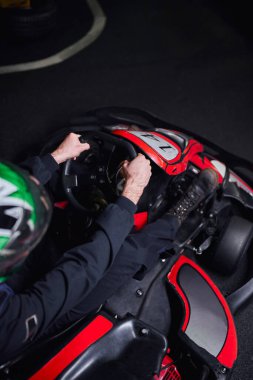 top view of man in helmet and sportswear driving go kart on indoor circuit, adrenaline concept clipart