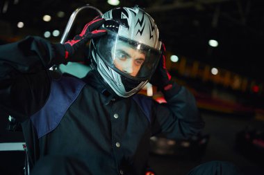Go kart sürücüsü pistte yarıştan sonra kaskını çıkarıyor, hız sürücüsü ve motor sporu konsepti
