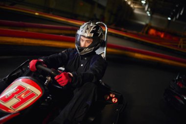 Kapalı devre, hız sürücüsü ve motor sporu konsepti üzerinde go kart arabasıyla yarışan kask yarışçısı
