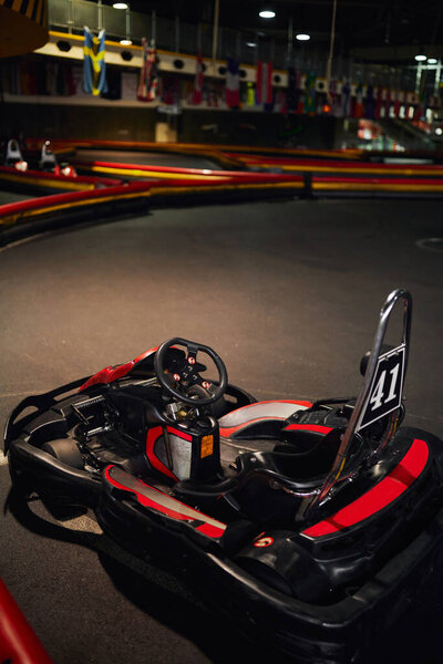 red racing car inside of indoor kart circuit, motor race vehicle, go cart kart for speed racing