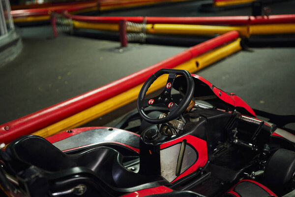 design of red racing car inside of indoor kart circuit, motor race vehicle, go cart, steering wheel