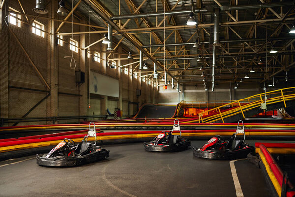 three racing cars inside of indoor  circuit, motor race vehicles,  go kart for speed racing
