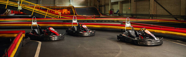 three racing cars inside of indoor kart circuit, motor race vehicles,  kart for speed racing, banner