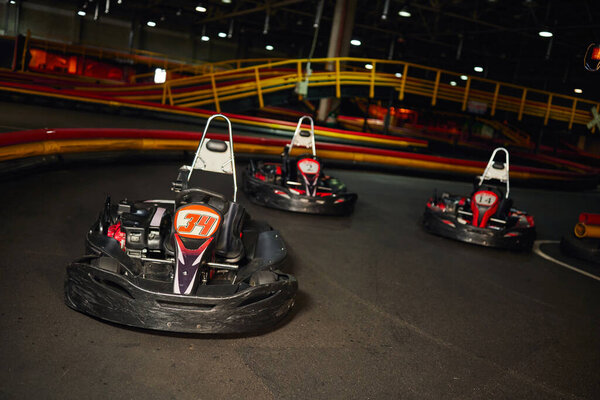 modern racing cars inside of indoor kart circuit, motor race vehicles, speed racing karting