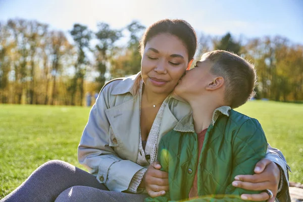 bonding and love, son kissing cheek of mother, happy african american woman and boy, fall
