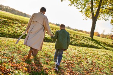 golden hour, mother and son walking in park, hold hands, autumn leaves, fall, african american clipart