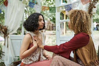 Boho kıyafetleri içinde çok ırklı kadınlar inziva merkezinde meditasyon yapıyor.