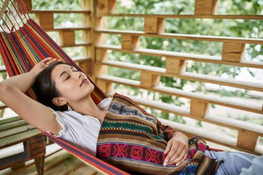 young attractive woman sleeping in hammock, relaxation, enjoyment, women retreat concept clipart