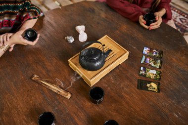 Çay fincanları, çaydanlık, tarot kartları ve palo santo ile kesilmiş kız arkadaş manzarası, kadınlar geri çekilme konsepti