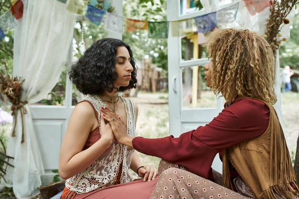 Boho kıyafetleri içinde çok ırklı kadınlar inziva merkezinde meditasyon yapıyor.