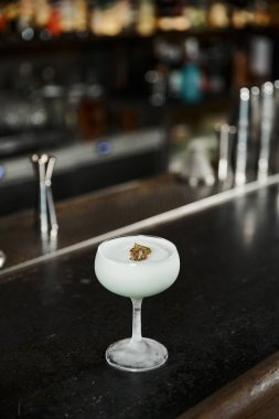glass of tasty alcoholic milk punch with kiwi slice on counter in bar, cocktail presentation clipart