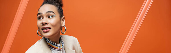 stylish fashion model in elegant street attire holding orange framework and flower bouquet, banner