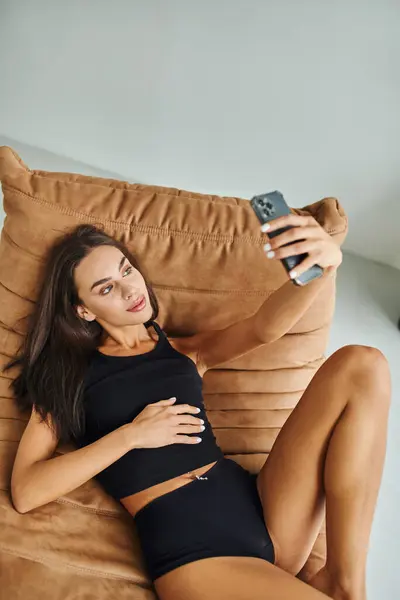 Kolsuz Tişörtlü Külotlu Güzel Bir Kadın Koltukta Dinleniyor Akıllı Telefondan — Stok fotoğraf
