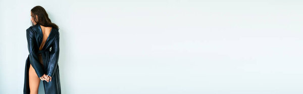 знамя брюнетки в кожаном пальто и кружевных трусиках, стоящих возле серой стены, сексуальные ноги