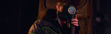 Gaz maskeli ve ceketli adam karanlık yeraltı tünelinde, felaket sonrası konsept, pankart